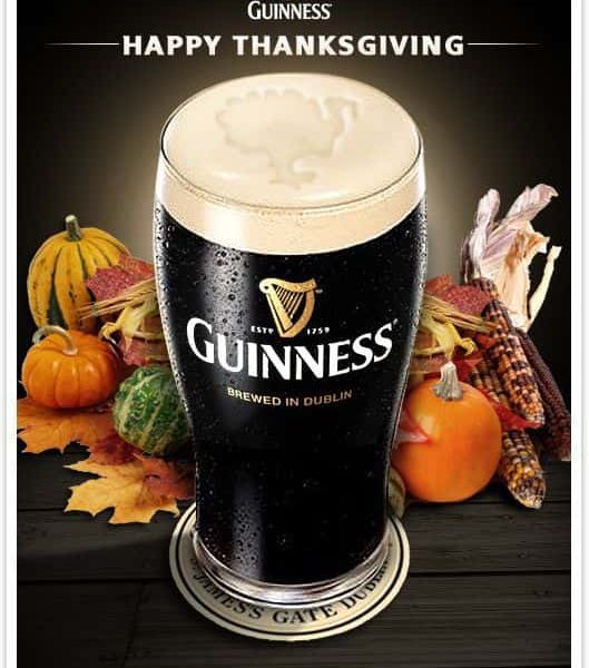 A festive guinness advertisement featuring a pint of beer with thanksgiving-themed decorations around it.