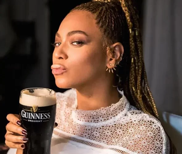 A woman enjoying a pint of guinness.