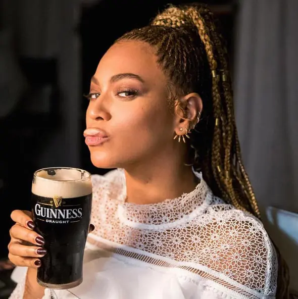 A woman enjoying a pint of guinness.