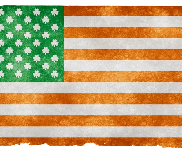 A textured illustration of the flag of the united states with the stars replaced by shamrocks, suggesting an irish-american theme.