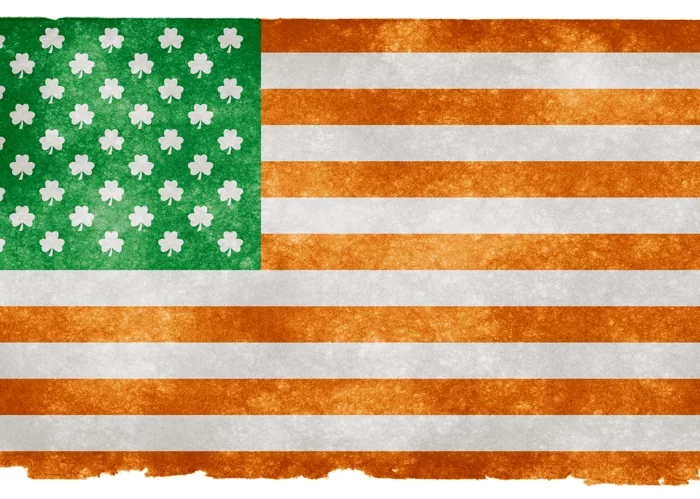 A textured illustration of the flag of the united states with the stars replaced by shamrocks, suggesting an irish-american theme.