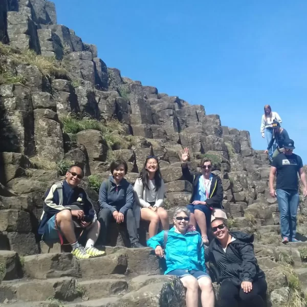 Group of tourists enjoying a sunny day at the giant's causeway, northern ireland.