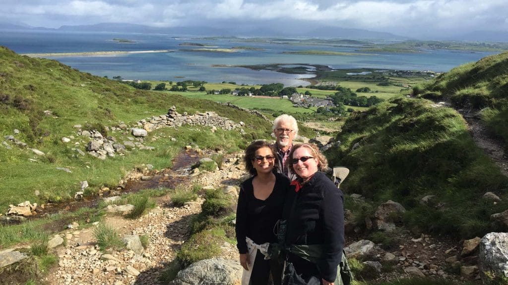 2 woman and an old man on a green hiking trail