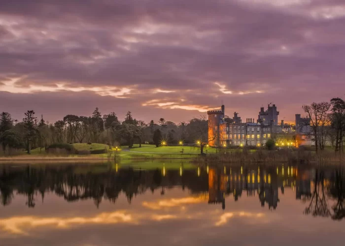 A serene twilight scene with a historic castle reflecting on a calm lake.