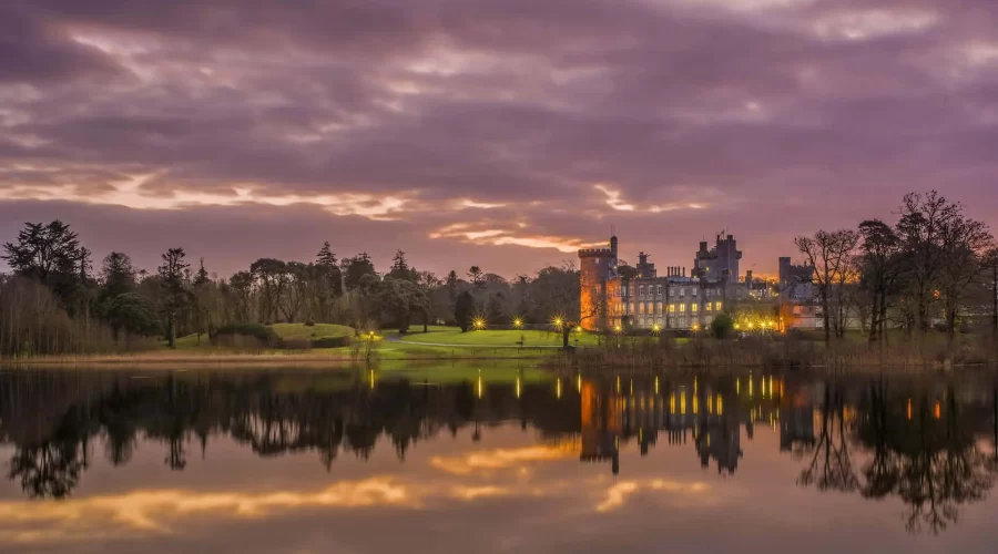 A serene twilight scene with a historic castle reflecting on a calm lake.