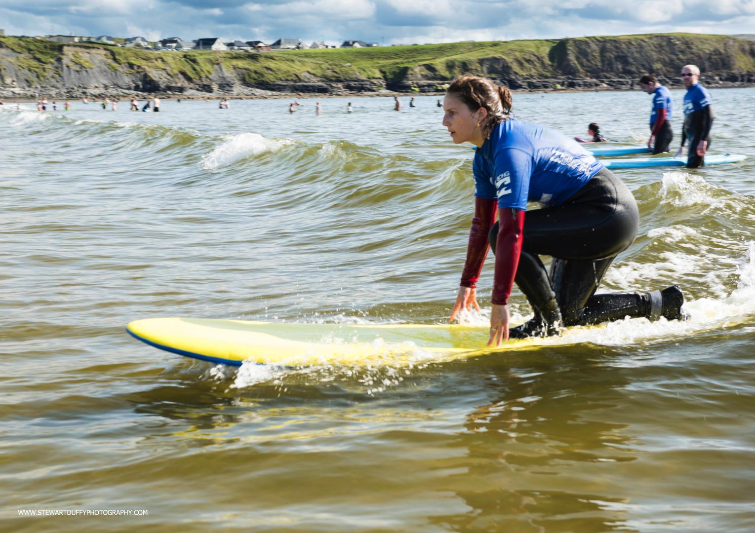 Girl surfing a wave in Ireland