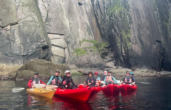 Group of kayakers exploring a rocky canyon during an Ireland tour.