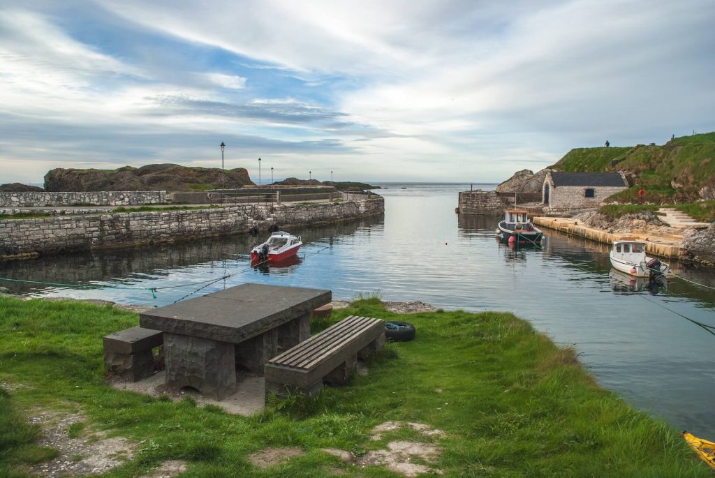 Red boat in body of water at Ballintoy Harbour