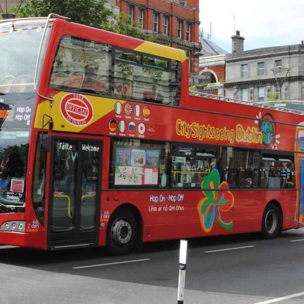 Red double-decker sightseeing tour bus on a city street.