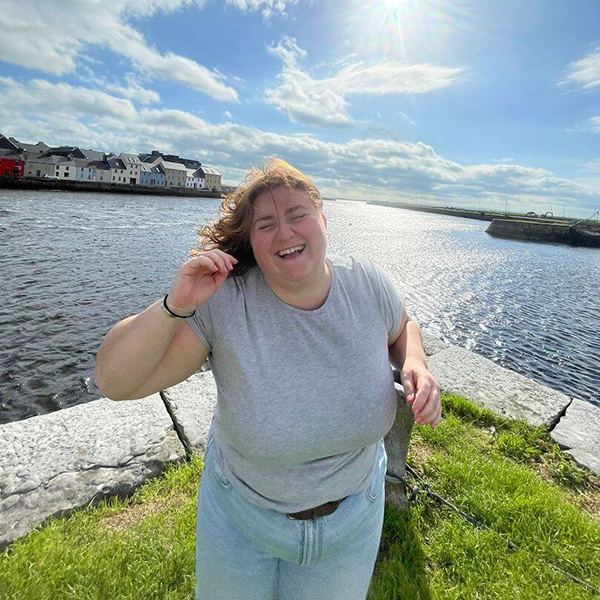 Woman laughing by the riverside on a sunny day during one of the small group tours in Ireland.
