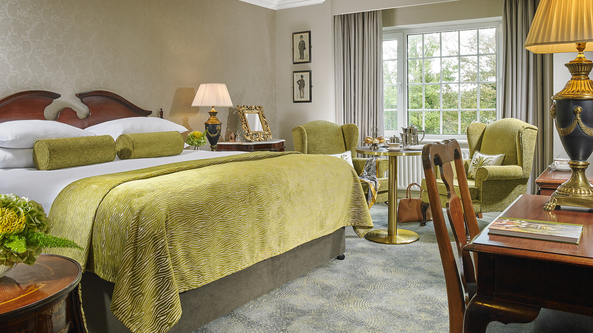 Elegant hotel room in Ireland with twin beds, traditional furniture, and a sitting area.