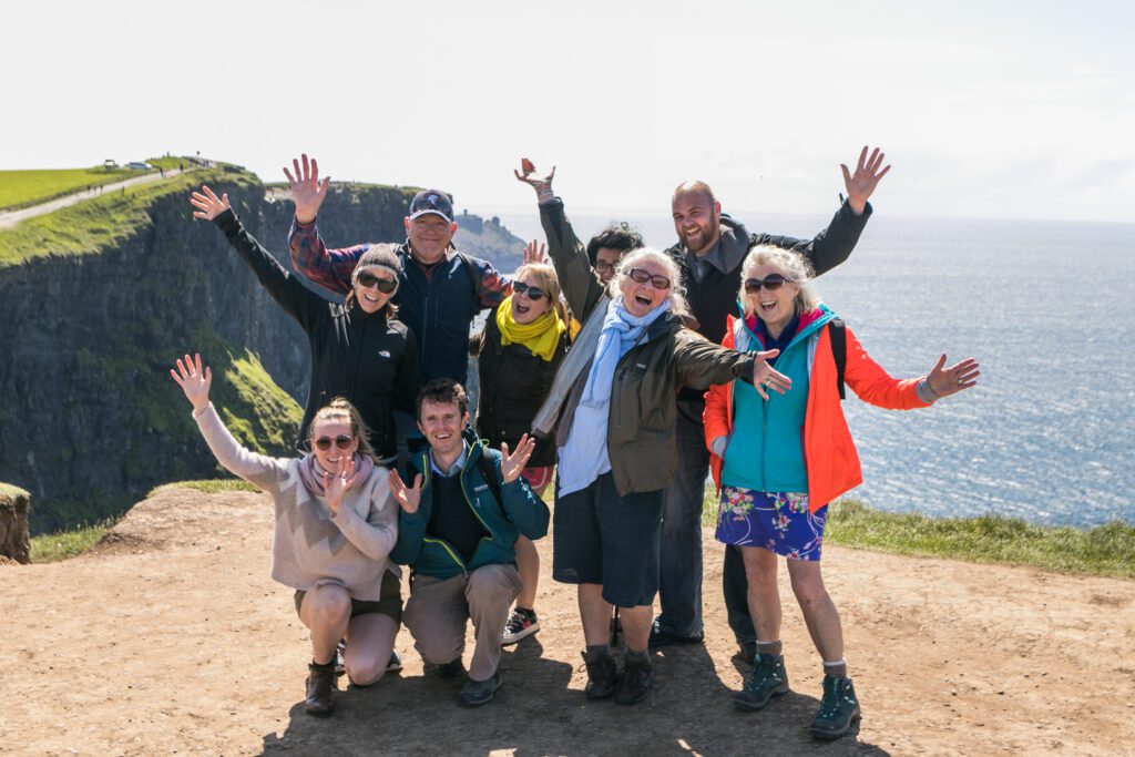 group of people taking a photo on mountain overlooking the water