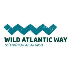 Logo of wild atlantic way featuring stylized blue waves above the text "wild atlantic way" and irish "slí fhiáin an atlantaigh.